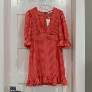 coral orange dress with ruffle detailing and V neckline